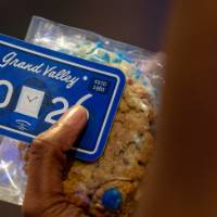 Grad holds Class of 2026 sticker and cookie